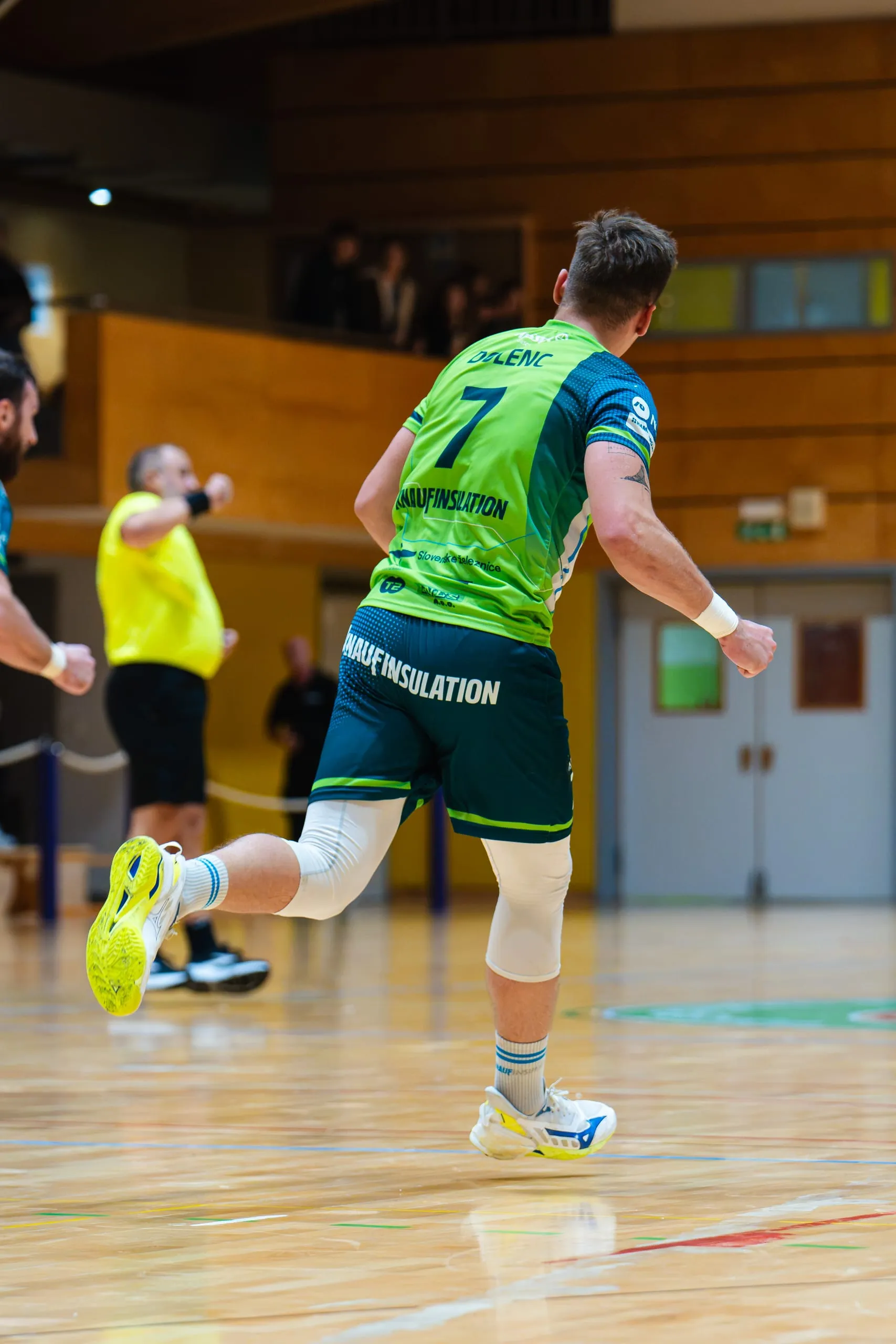 Andrej Dolenc s številko 7 v zelenem gostujočem dresu RD Škofja Loka med tekmo proti RK Sviš, posnet od zadaj